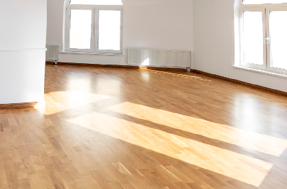 Bright open living room with hardwood flooring and arched windows after home renovation