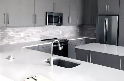 Modern gray kitchen remodeling with custom cabinets, white countertops, and center island