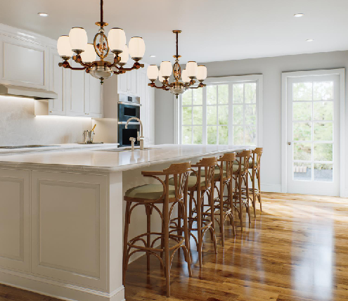 Classic white kitchen with large island, bar seating, chandeliers, and wood flooring