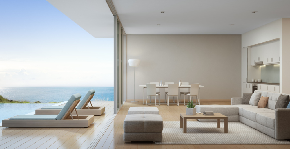 Waterfront home addition with open-concept living room, sliding glass doors, pool deck, and ocean view
