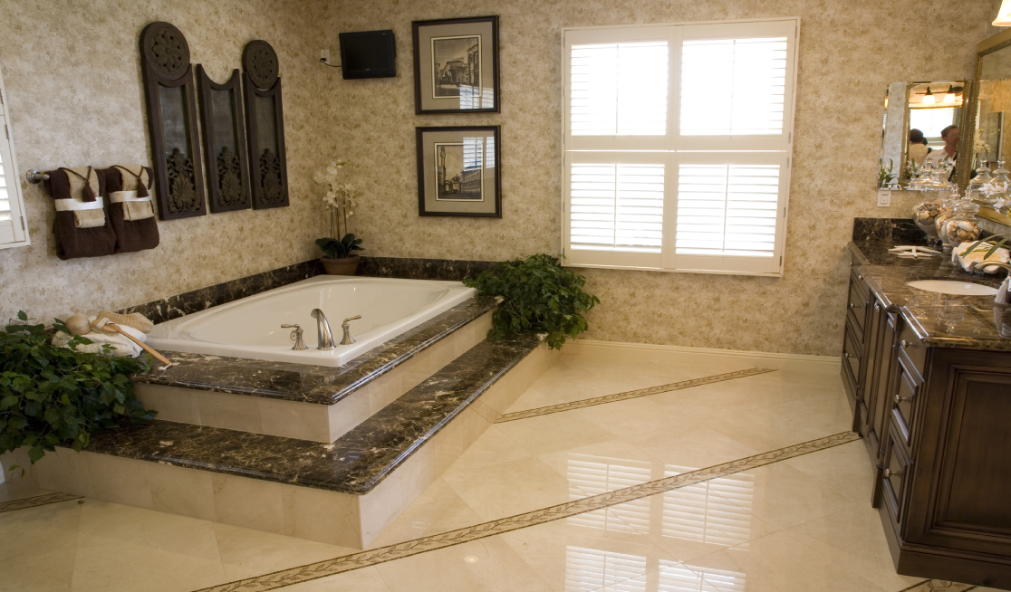 Luxury bathroom remodel featuring a built-in soaking tub, stone countertops, and custom vanity cabinetry