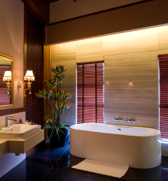 Spa-inspired bathroom remodel featuring a freestanding soaking tub, elegant wall finishes, modern vanity, and warm ambient lighting.